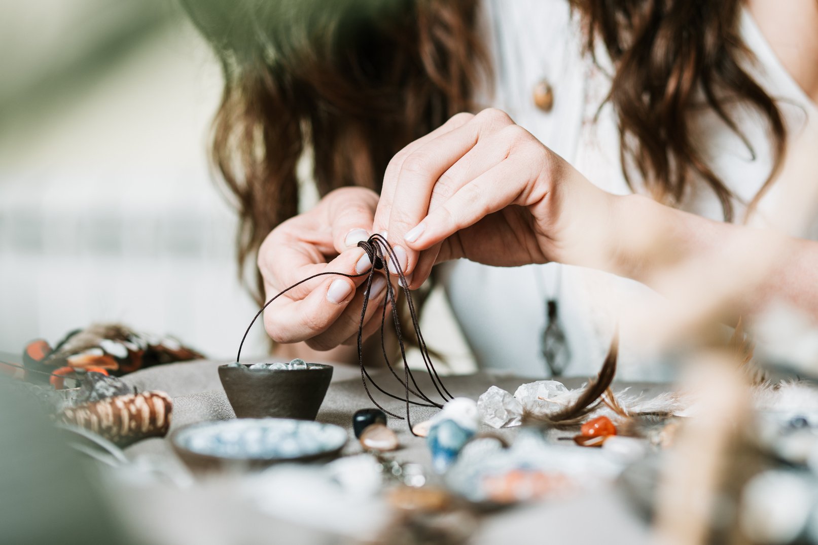 Woman hands making handmade gemstone jewelry, home workshop. Woman artisan creates jewelry. Art, hobby, handcraft concept